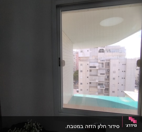 חלון עם תריסים סגורים ומקדחה על השולחן